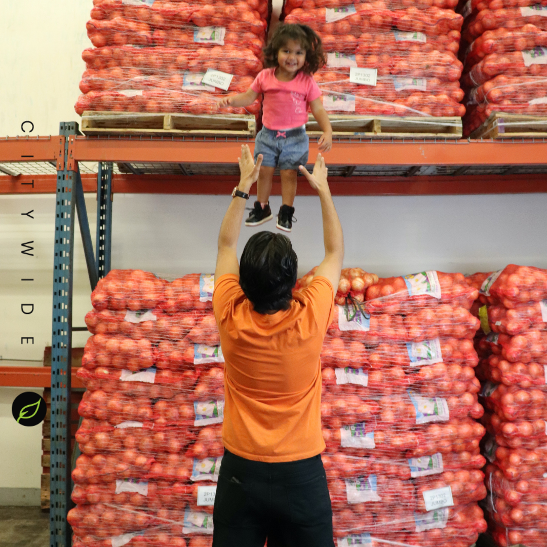 City Wide Produce's Gopal with daughter by crates of vegetables